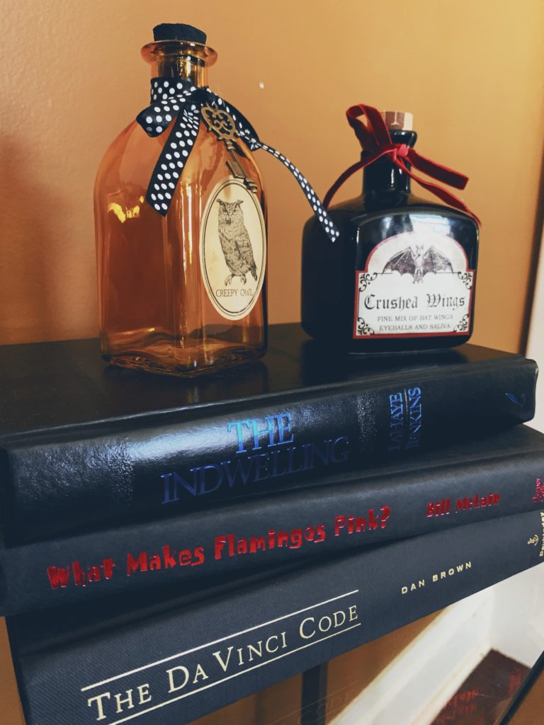 chic halloween decor, two potion bottles sitting on top of black hardback books