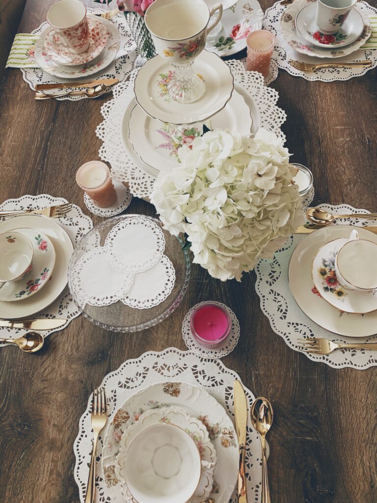 table spread of beautiful tea sets and a vase of flowers set for a Mother's Day brunch