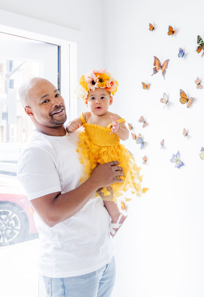 Baby girl dressed in beautiful yellow dress ready for her garden party birthday to begin