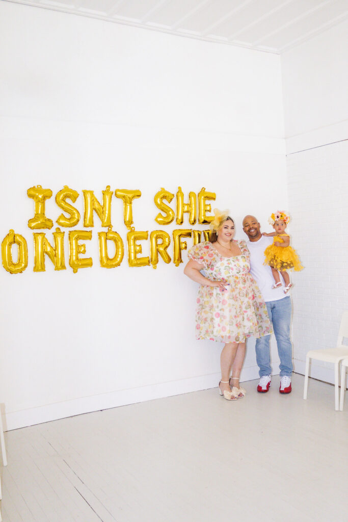 family picture standing against wall at Gisele's Garden Party themed birthday