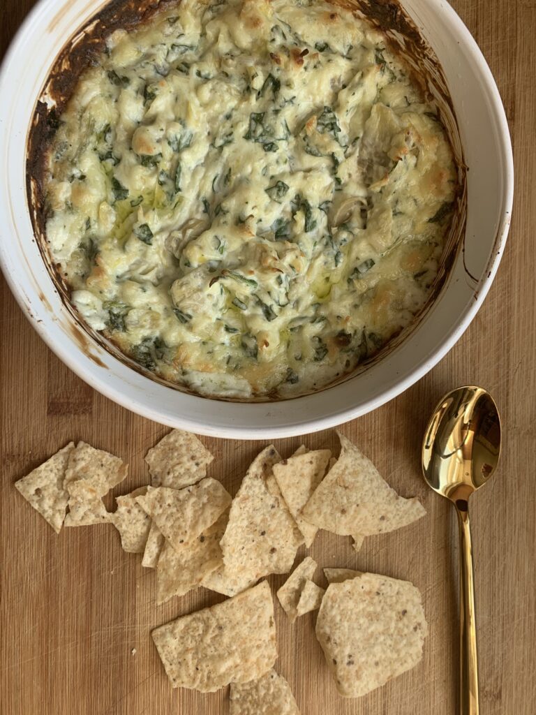 a bowl of spinach artichoke dip appetizer that can be served at a small gathering 