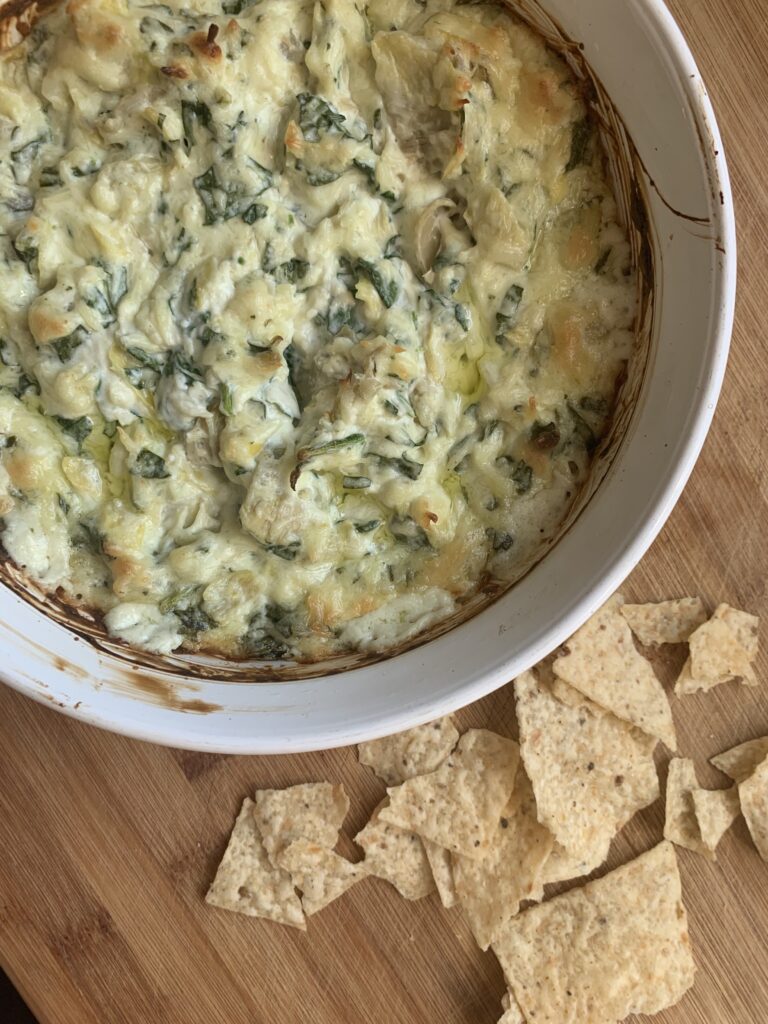 a homemade bowl of spinach artichoke dip appetizer for a party or tailgate.