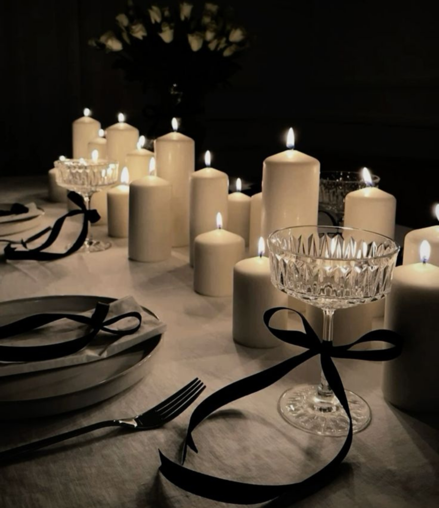 white pillar candles lit as a centerpiece for a NYE celebration at home