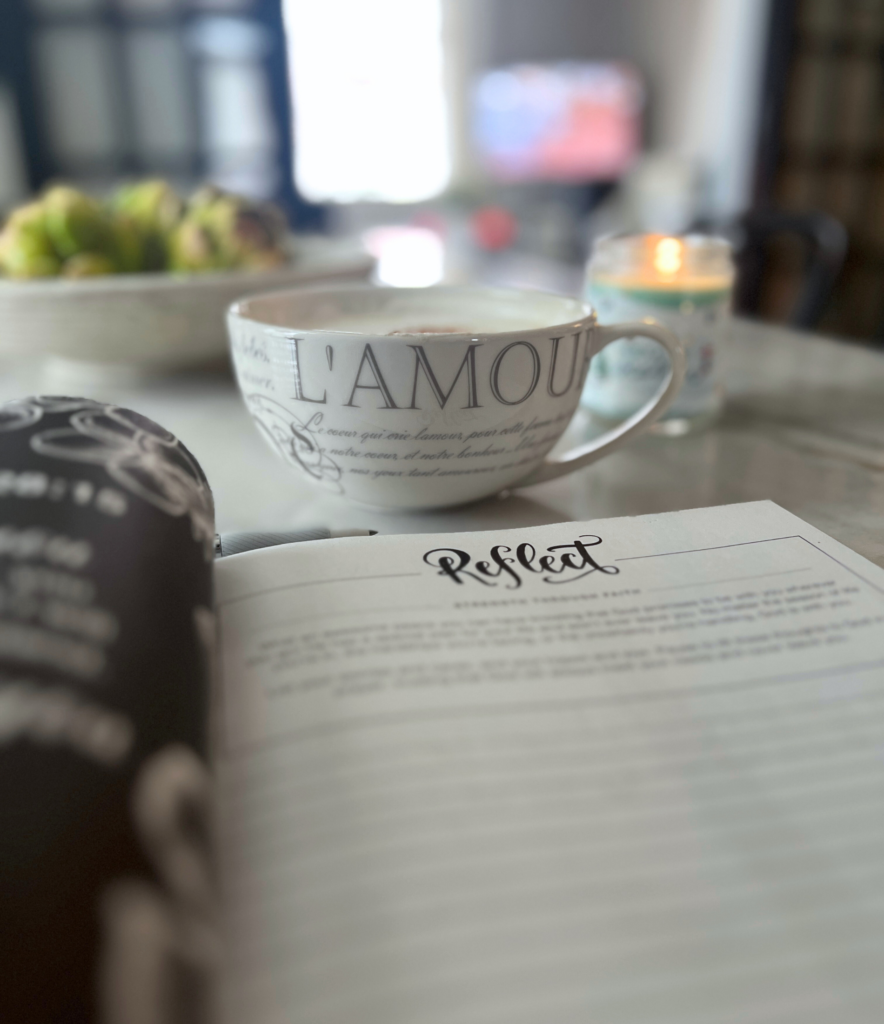 A picture of a coffee cup sitting on a table with a candle beside it for a blog post about simple habits to refresh your routine