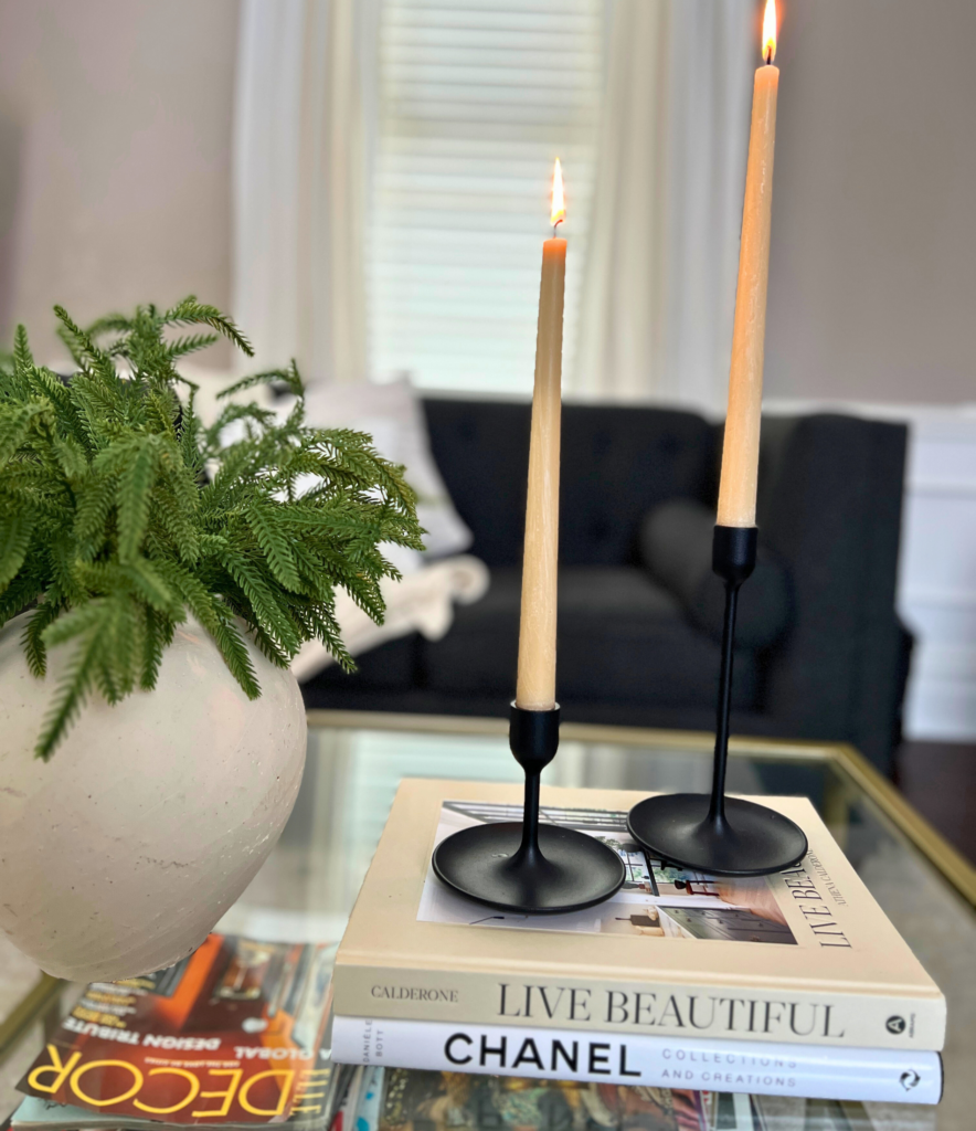 A picture of a coffee table with candlesticks sitting on top of coffee table books for a blog post about simple habits to refresh your routine