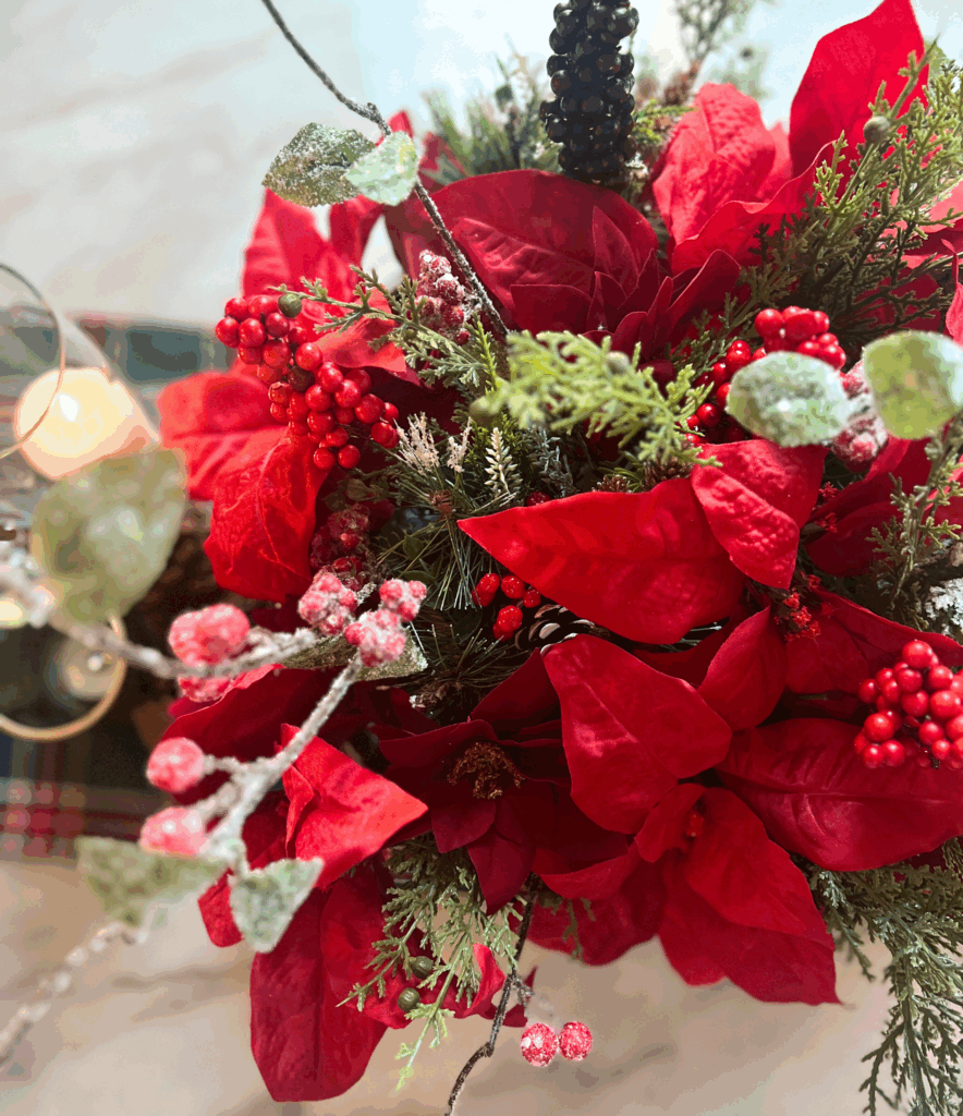 Poinsettias in a beautiful christmas centerpiece for a Ralph Lauren inspired Christmas Holly berry stems in an organic modern vase sitting on console table for a blog post about the Ralph Lauren Christmas trend.