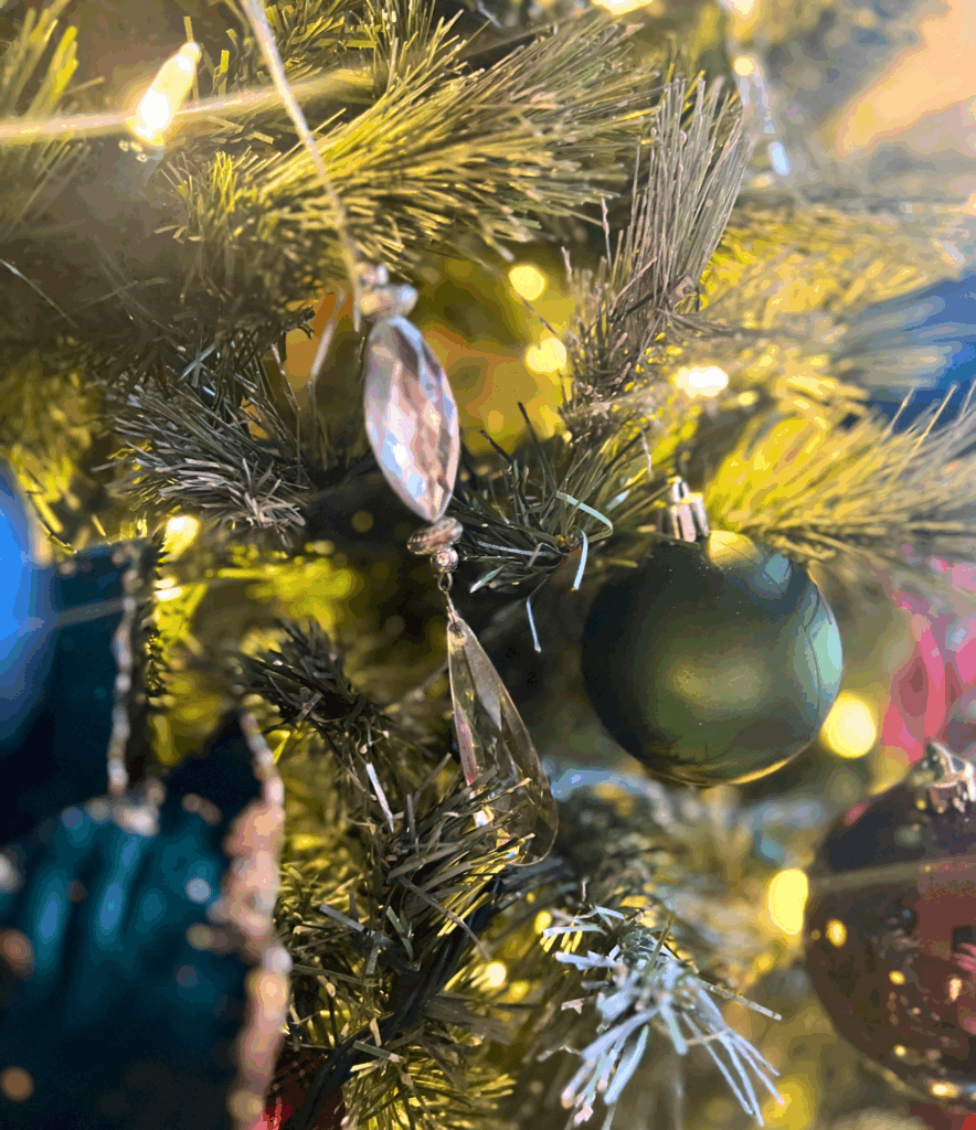 Crystal styled christmas tree ornament hung beautifully on a Ralph Lauren inspired Christmas tree Holly berry stems in an organic modern vase sitting on console table for a blog post about the Ralph Lauren Christmas trend.