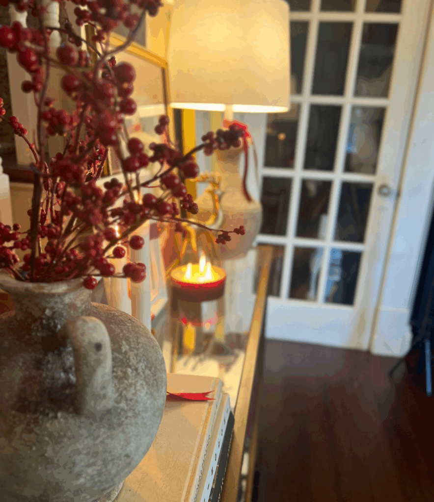 Holly berry stems in an organic modern vase sitting on console table for a blog post about the Ralph Lauren Christmas trend.
