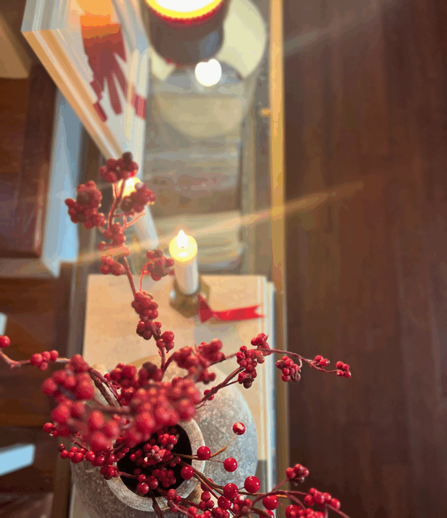 Holly berry stems in an organic modern vase sitting on console table for a blog post about the Ralph Lauren Christmas trend.
