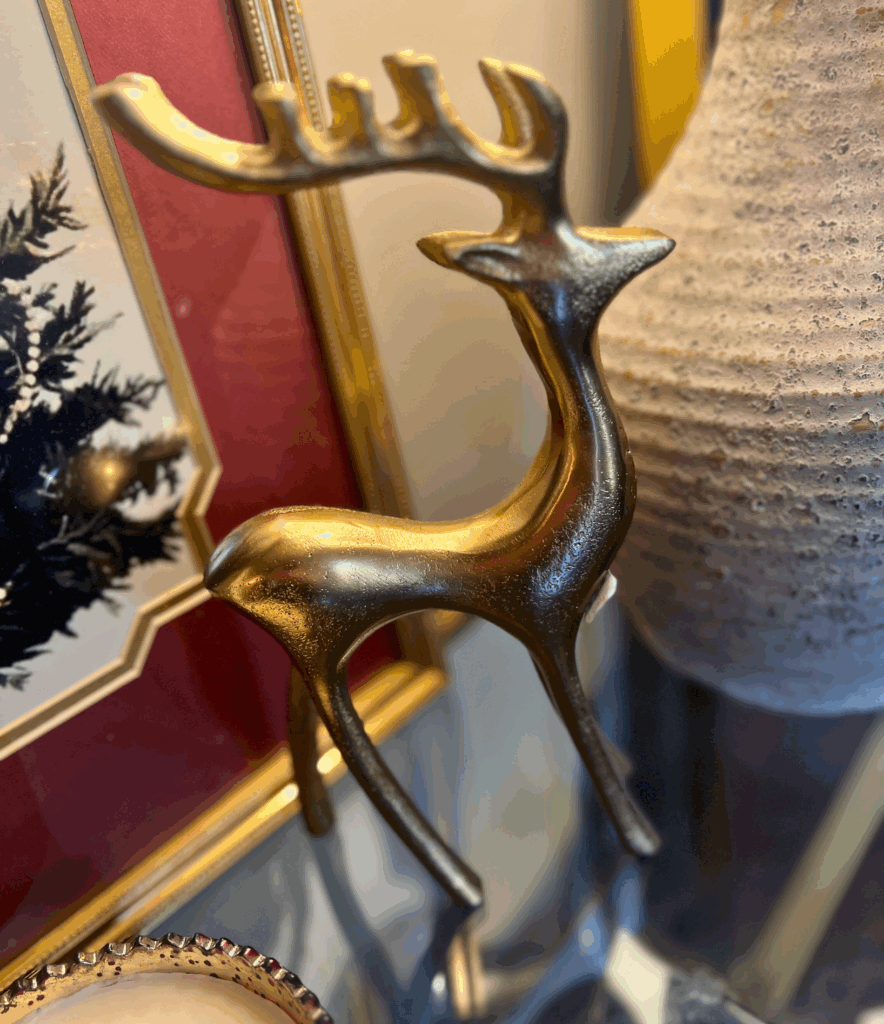 Gold reindeer statue sitting on a styled console table for a blog post about the Ralph Lauren Christmas trend.
