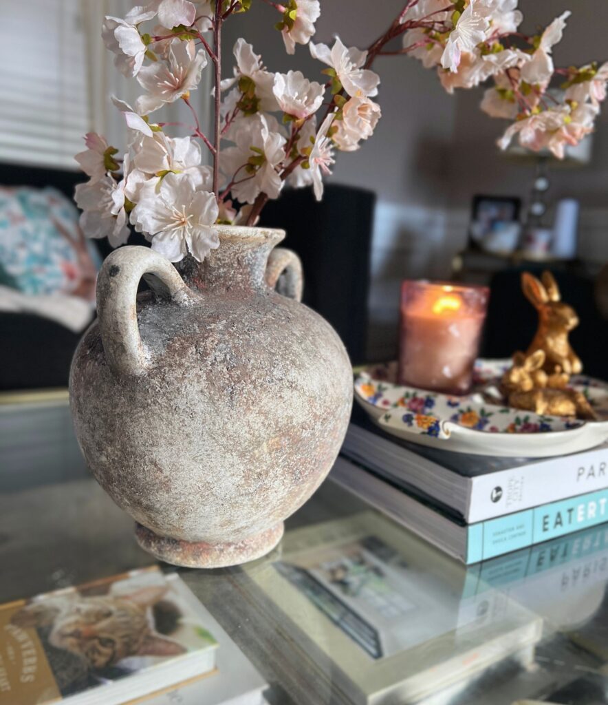 simple spring decor styled on a coffee table with delicate budding florals and soft tones with coffee table books